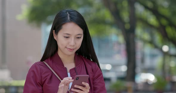 Woman look at smart phone in city park