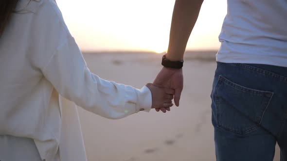 Aimed Close Up Footage of Holding Hands Couple Walking in Romantic Relationship Under Sun and Blue