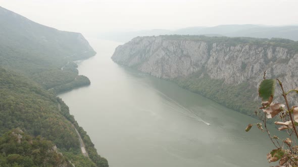 Narrowest point of Danube river gorge 4K 2160p 30fps UltraHD footage - Boats passing on state border