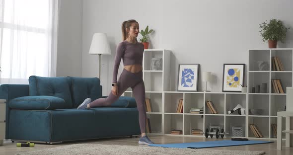 Woman Is Squatting in Living Room of Modern Apartment Training and Doing Physical Exercise for