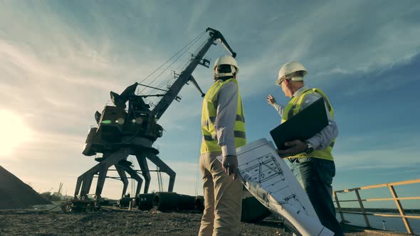 Two Engineers Are Observing a Mining Site with Machinery