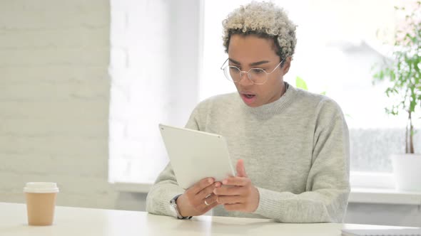 African Woman Reacting to Loss on Tablet in Office