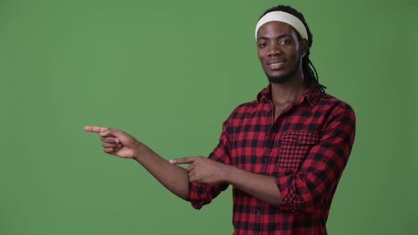 Young Handsome African Man with Dreadlocks Against Green Background