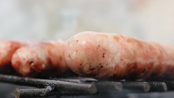 Tasty looking raw sausage in own juices on the barbecue 4K 2160p 30fps UltraHD footage - Moutwaterin