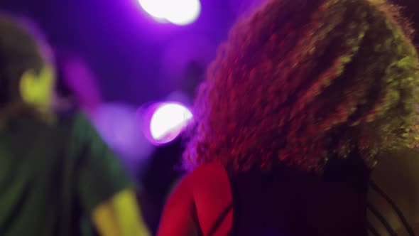 Girl with Beautiful Curly Hair Dancing Vigorously at Festival or Disco