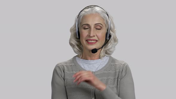 Pretty Senior Lady Wearing Headset and Smiling