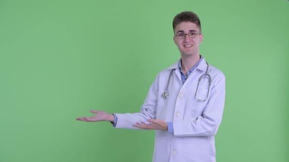 Happy Young Man Doctor Talking While Showing Something