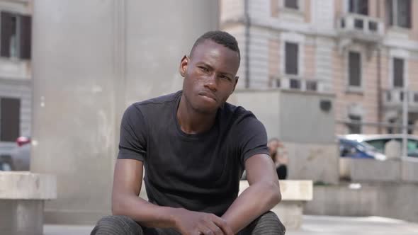 Proud angry young black african man staring at camera- outdoor