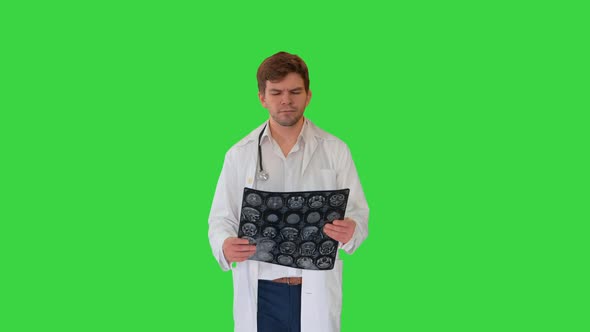 Concentrated Male Doctor Examining Computed Tomography While Walking on a Green Screen, Chroma Key.