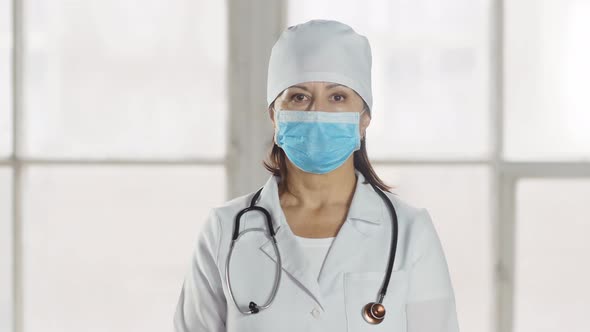 Portrait Of Lady Doctor In Mask Looking At Camera. professional female doctor wearing uniform with p