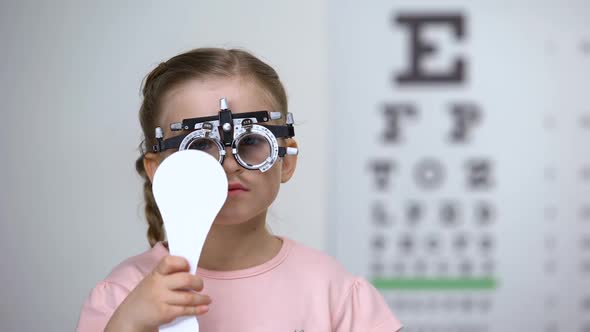 Child in Special Glasses With Eye Closed Checking Vision, Astigmatism Diagnosis