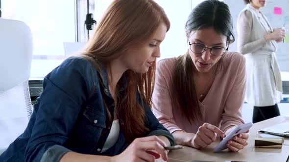 Slow motion shot of businesswomen using smartphone at the office