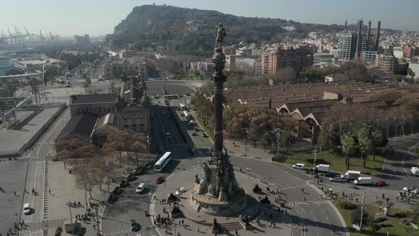 AERIAL: Slow Overhead Flight Over Columbus Monument in Barcelona, Spain with Palm Trees on Beautiful