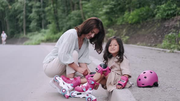 Pretty Mother and Kid in Rollerblades on the Road