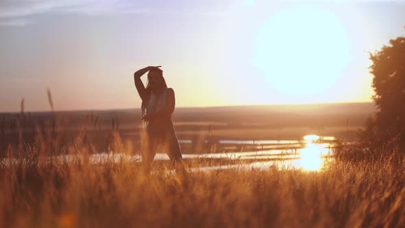 Woman with Long Braids Dancing on Sunset Field