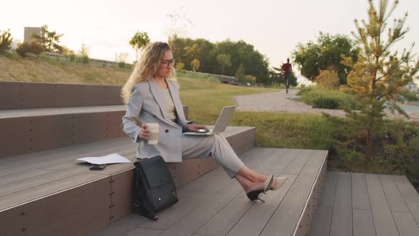 Business Woman Working on Laptop Outdoors