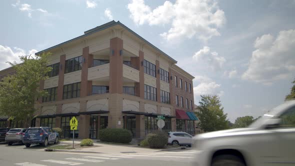 Static View Of Business Building At The Corner Of The Street In Apex. North Carolina With Vehicle Pa