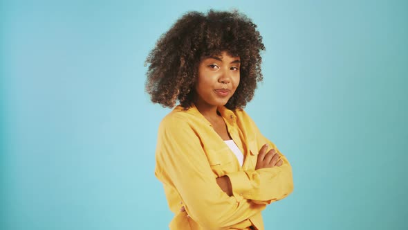 Africanamerican Lady Smiling Laughing and Flirting Looking at you While Posing Sideways Against Blue