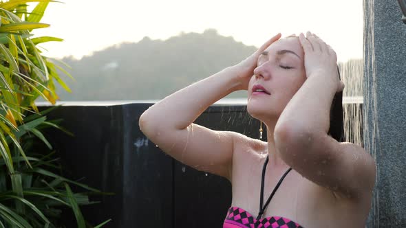 Girl in Coloured Bikini Chills Under Hotel Outdoor Shower