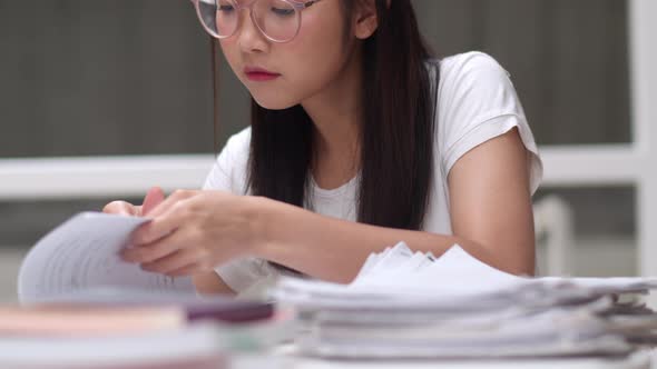 Young undergraduate girl do homework, read textbook, study hard for knowledge and education.