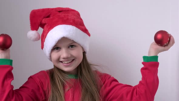 Portrait of Smiling Happy Little Girl in Christmas Santa Hat on White Background alt