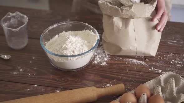 Preparing ingredients for dough. Wome in kitchen preparing flour dough donuts. Making homemade donut