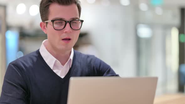 Sick Young Businessman with Laptop Coughing 