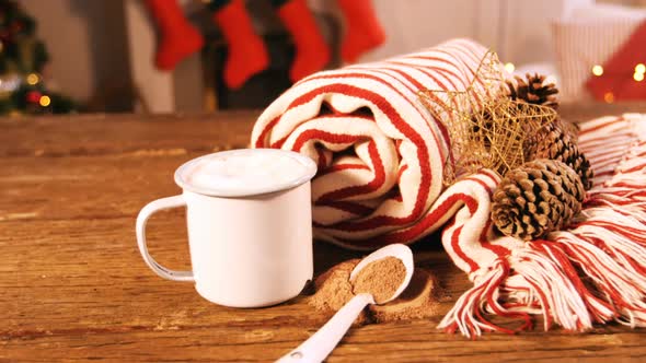 Rolled blanket with pine cone and coffee mug