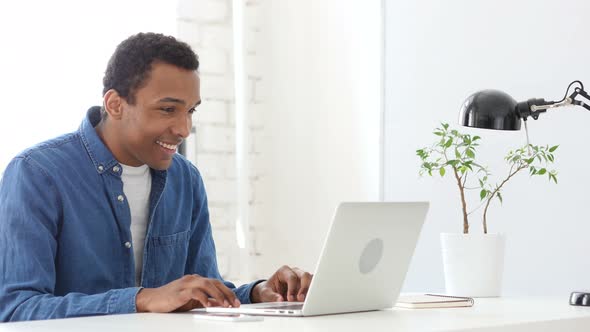 Happy Afro-American Man Working On Laptop in Office