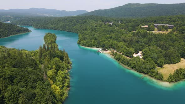 View of the Plitvice Lakes National Park with many green plants and beautiful lakes and a jetty on t