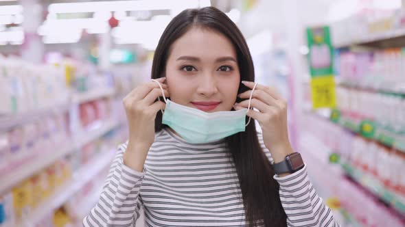 Young Asian woman in medical mask grocery walk toward camera shot, at supermarket