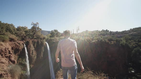 Back View of Mid Adult Caucasian Man Running to Edge of Abyss