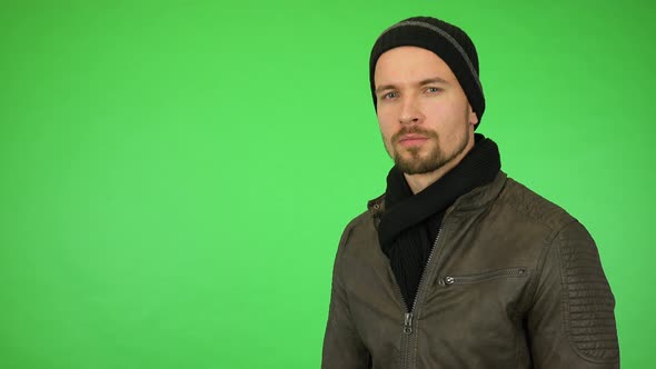 A Young Handsome Man in a Winter Outfit Looks Seriously at the Camera - Green Screen Studio