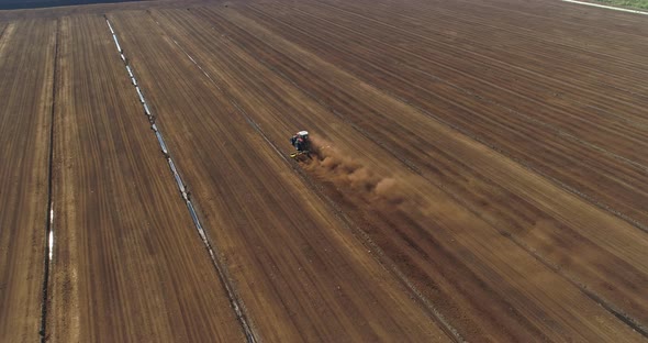 Peat Harvesting Tractor Plowing on Field Aerial View