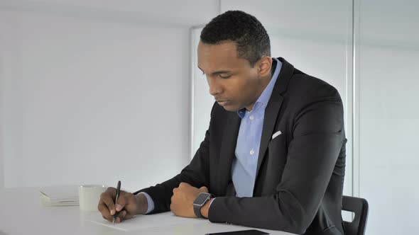 Casual Afro-American Businessman Writing at Work Paperwork