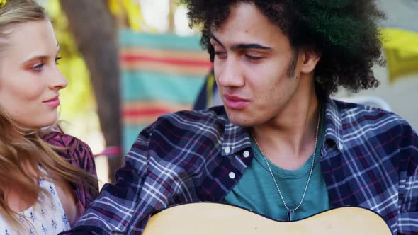 Man playing guitar for his woman in park 4k