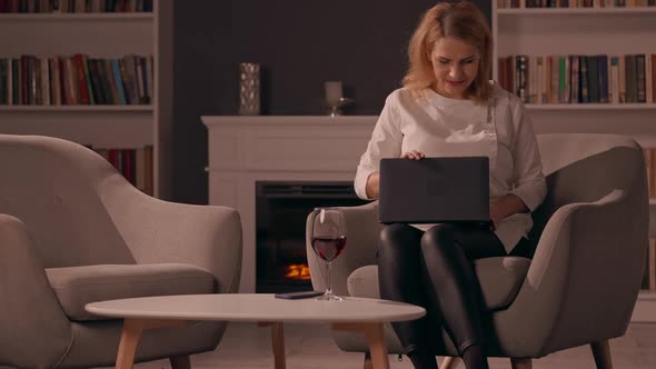 Adult Female Using Computer Relish Drink in Living Room