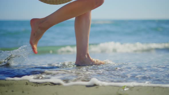 Woman legs being washed by ocean waves