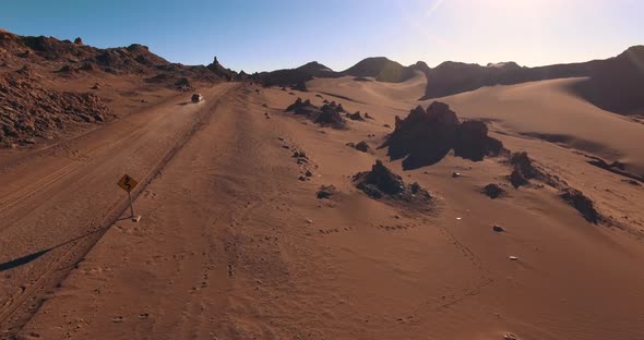 Lone Car Drives the Desert Road Crossing the Moon Valley. The Landmark of Atacama Desert. Chile