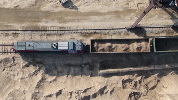 Loading Sand Into Rail Cars with the Help of a Career Excavator