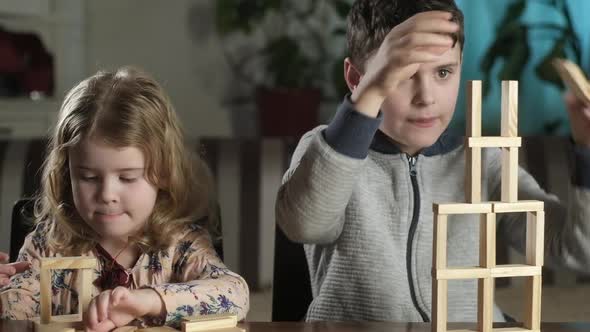 Children play with blocks. boy and girl build tower of wooden blocks together