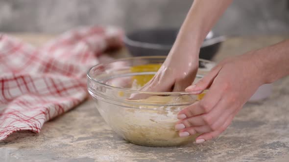 Woman Kneading Dough in Glass Bowl