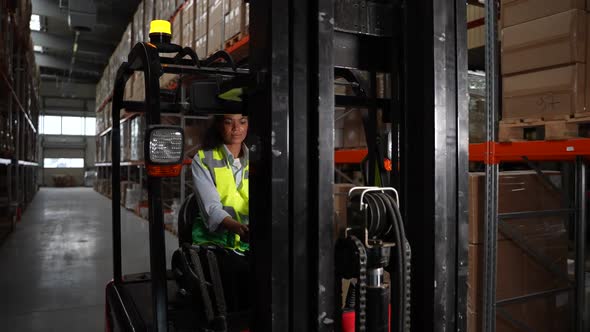 Woman Forklift Driver Riding Around Storehouse