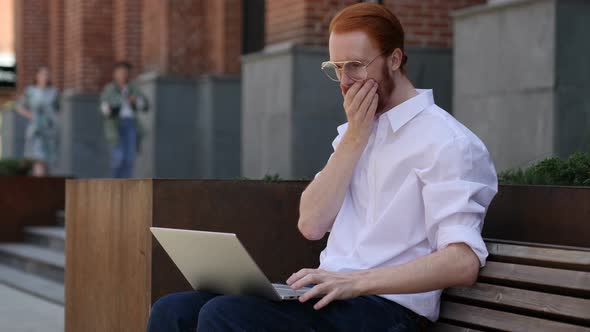 Astonished Designer Wondering while Using Laptop Sitting on Bench