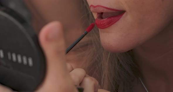 Close Up Slowmotion Footage of How a Girl with a Burgundy Pencil for Makeup Outlines the Contour of