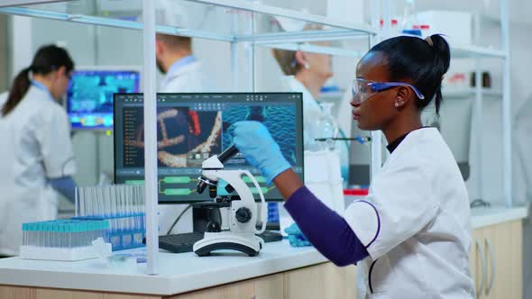 African Scientist Checking Sample of Virus Using Microscope