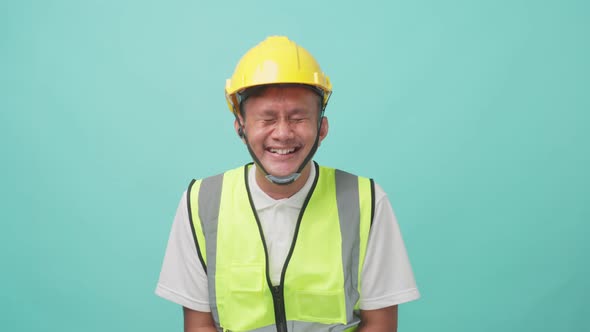 Portrait of male engineer looking at camera and smiling with isolate green screen in background.