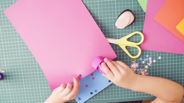 Little Girl Cutting Flowers from Colored Paper