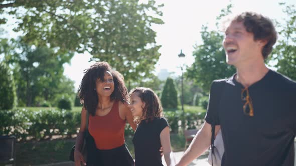 Cheerful multiethnic family talking and walking in the park