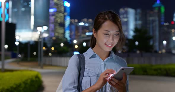 Woman Look at Mobile Phone in City at Night